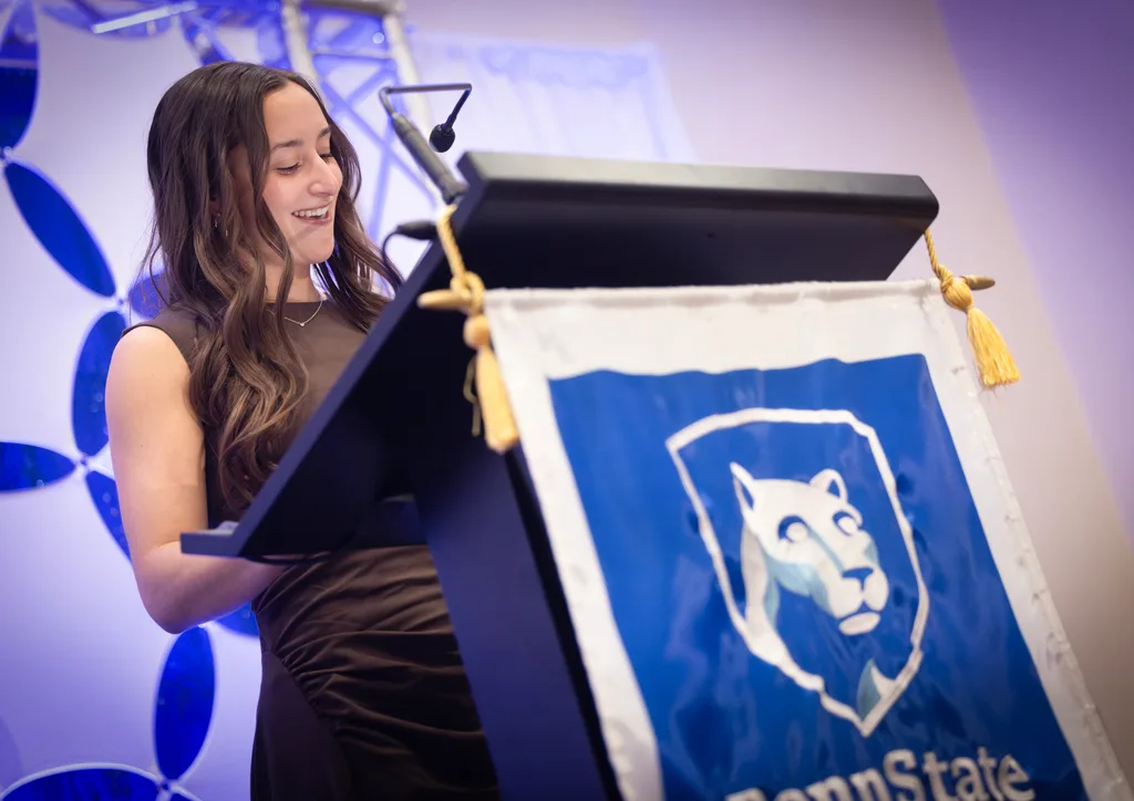Jessica Santucci, student speaker for the class of 2026, makes remarks from a lectern with a Penn State banner