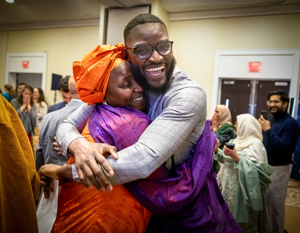 A matching MD student smiles and hugs a loved one during a Match Day celebration