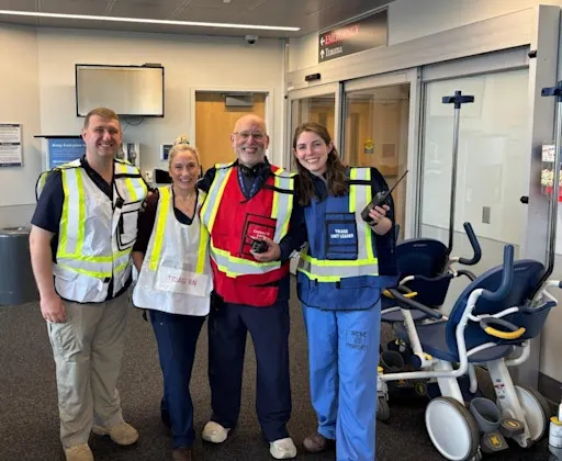 Four people in high visibility vests during a drill inside a medical center