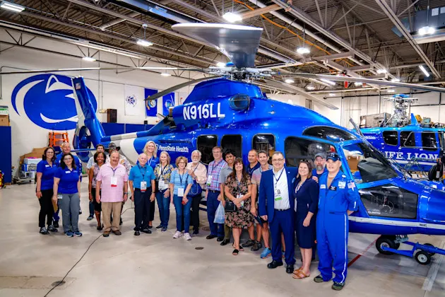A group of people in front of the Life Lion helicopter.