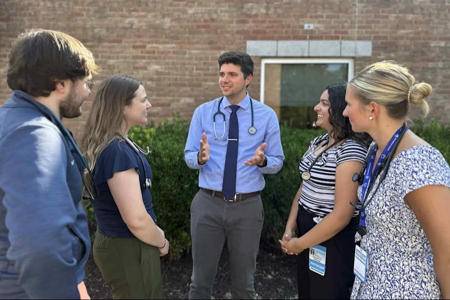 Dr. Michael Partin in the center speaking to four trainees