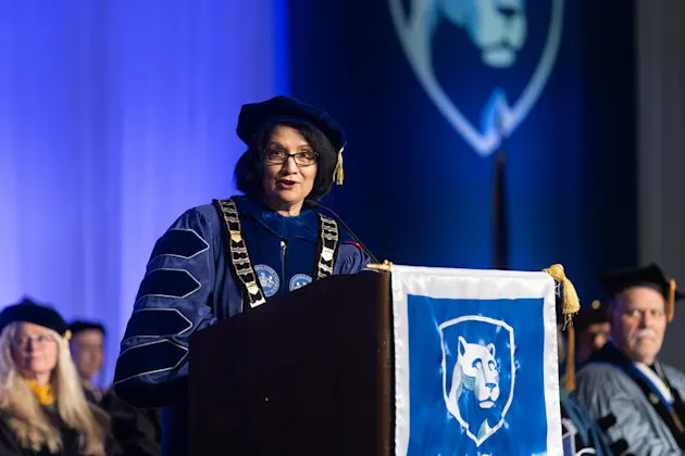 Penn State President Neeli Bendapudi gives remarks at a lectern with a Penn State banner on it