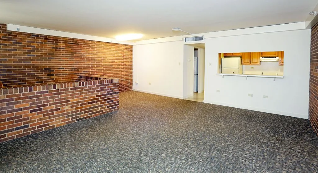 Living and dining area in University Manor East shows an open area leading in from the kitchen with a counter between rooms.