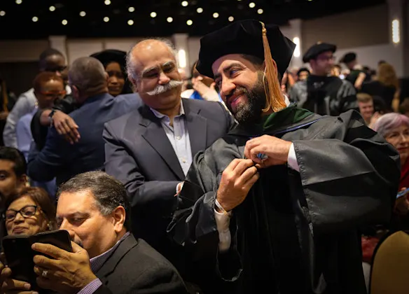Medical student Agustey Mongia is hooded by his father Gagan during the Medical Student Hooding Ceremony