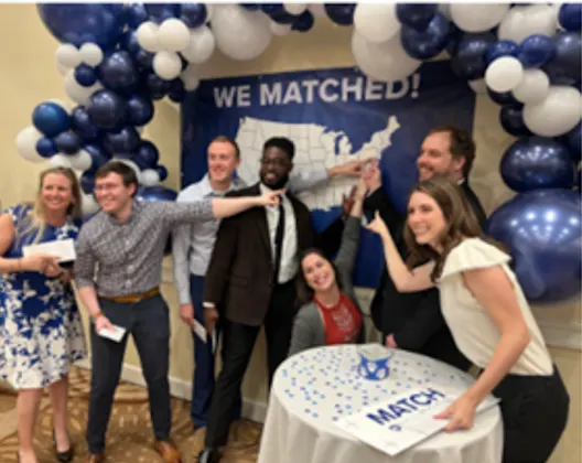 Seven students point to a U.S. map under the title 'We Matched!' during Match Day