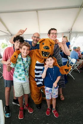 A family posing with the Nittany Lion mascot