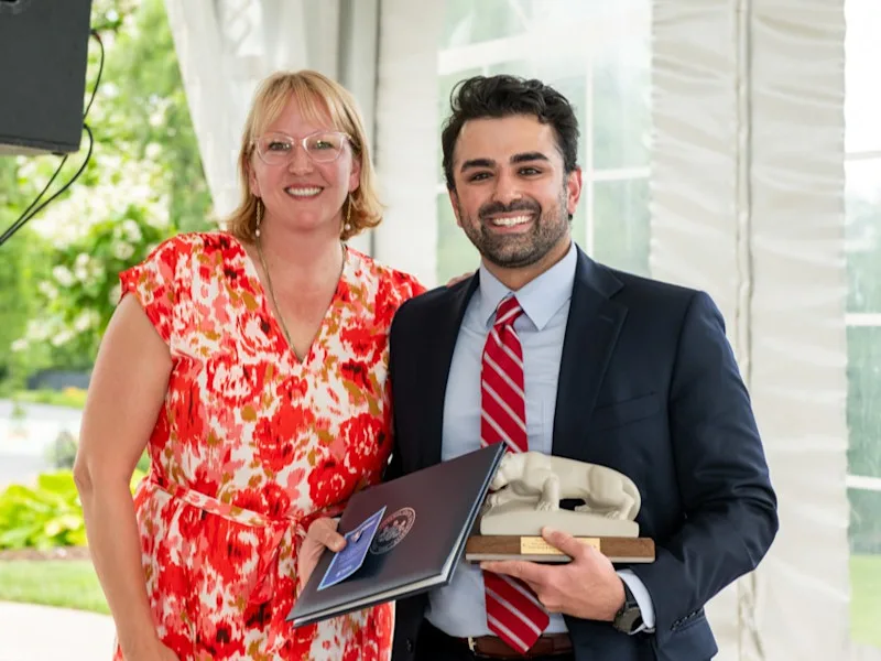 Dr. Aniruddha Parikh accepts certificate and lion statue from fellowship program director at graduation.