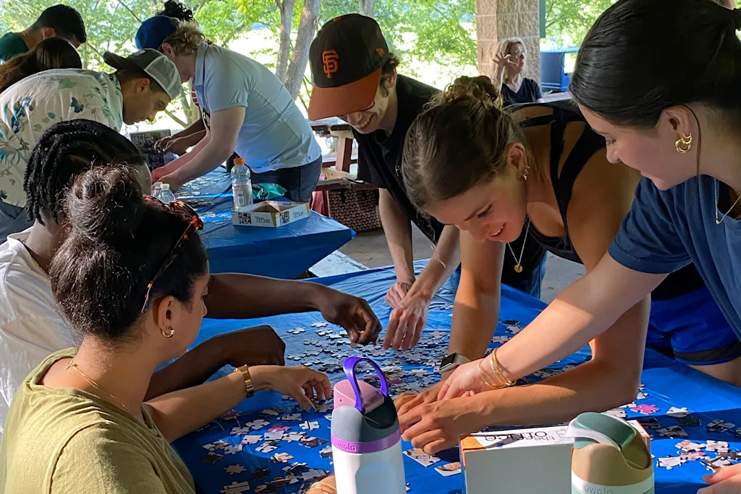Program participants work together at a table solving puzzles as a teambuilding activity