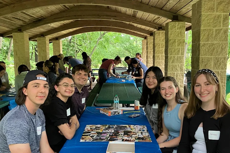 Program participants work together at a table solving puzzles as a teambuilding activity