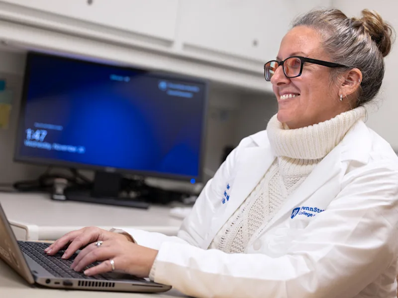 A coordinator at the Neuroscience Institute sits at a desk working on a computer