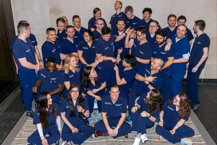 A group of around 30 residents making silly faces and poses