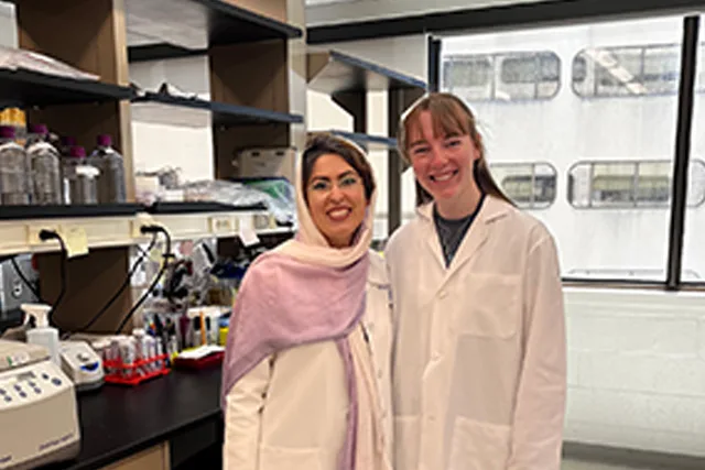 A program participant works with a senior lab member in a PSCI research lab.