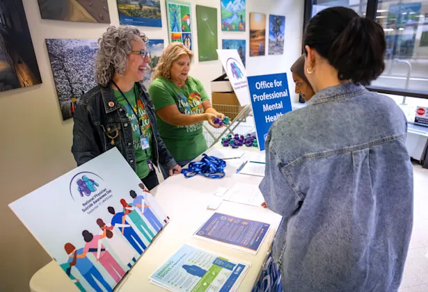 Amy Keisling, left, and Trudi-Ann Middleton Flynn share information from behind a table at an event.