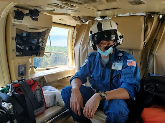 An EMS fellow sits on the side of a Life Lion helicopter.