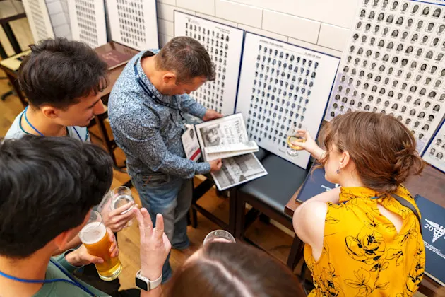 A group of people looking at old yearbooks and class photos.