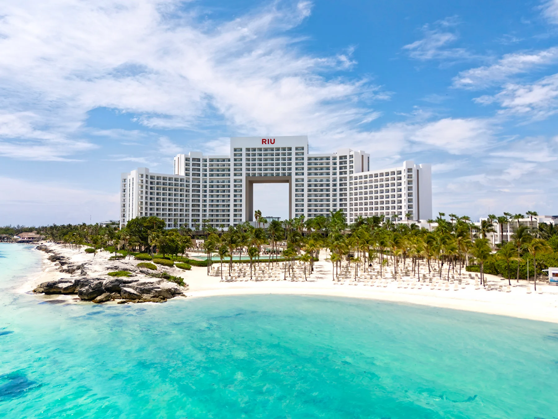 Exterior view of Hotel Riu Palace Peninsula with beach and ocean in front of it