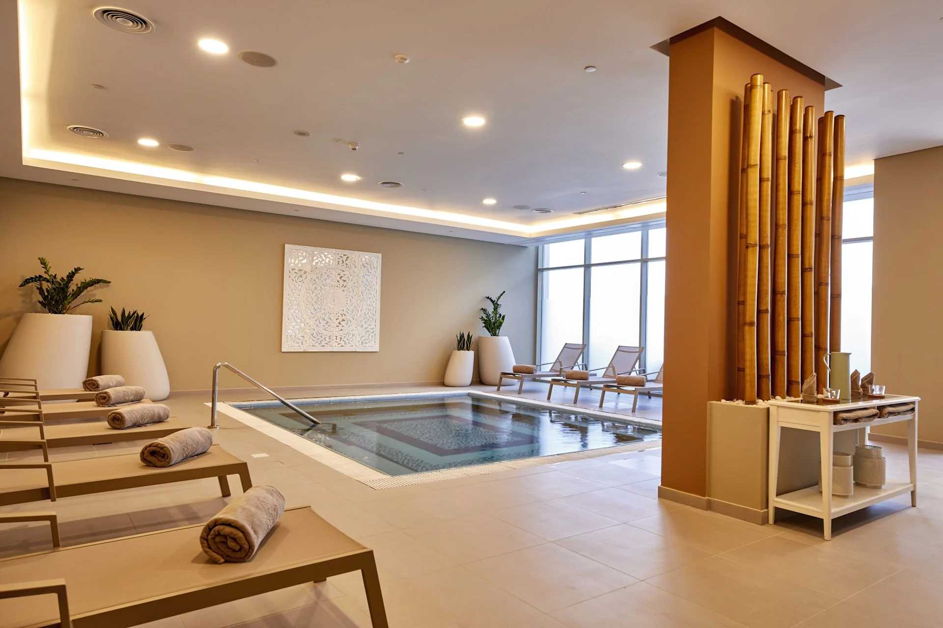 Spa with indoor pool, soft lighting and loungers