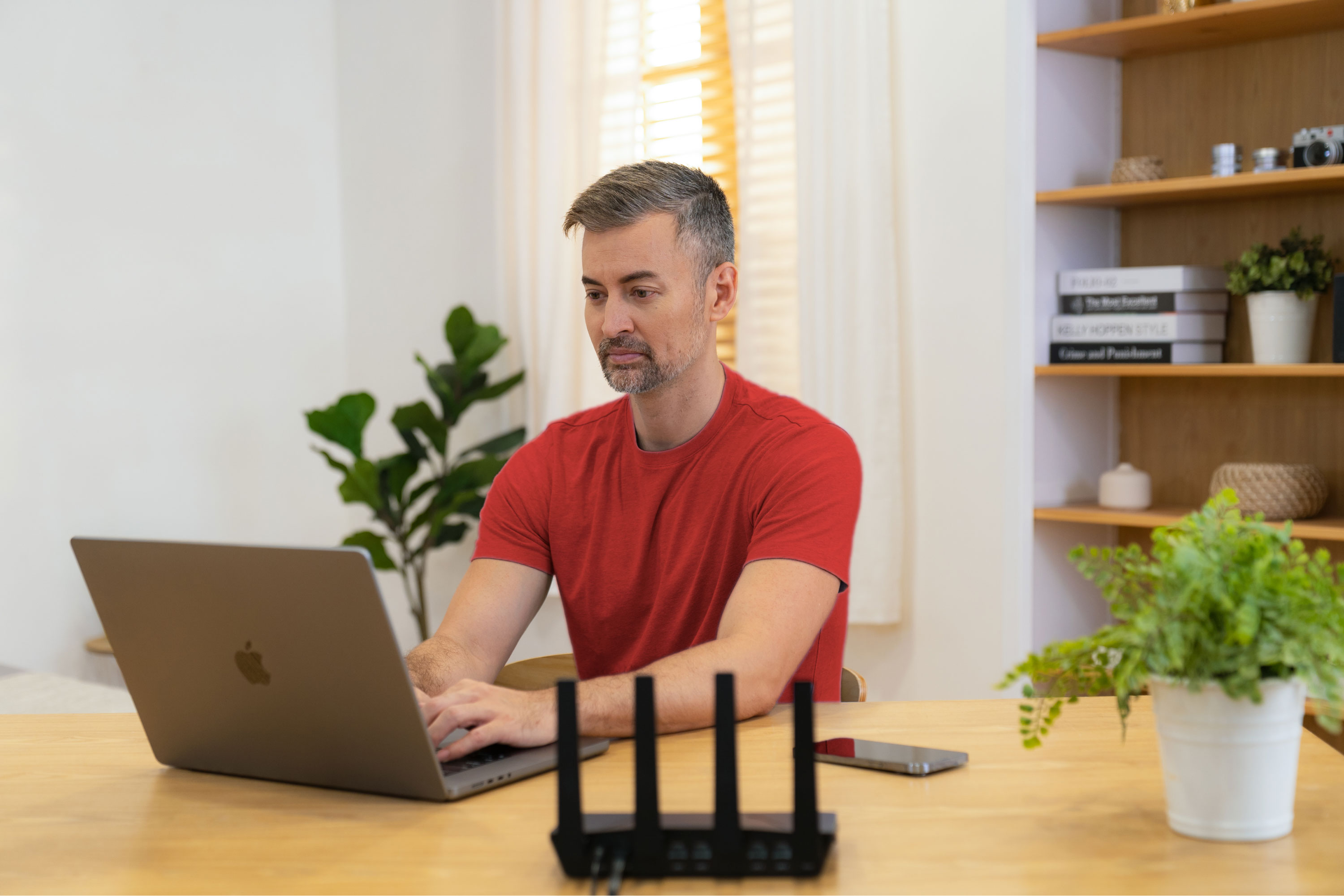 Lifestyle image of ExpressVPN Aircove with a man on a laptop.