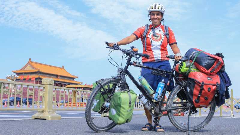 Luisa Rische steht mit ihrem Fahrrad auf dem Tian'anmen Platz in Peking.