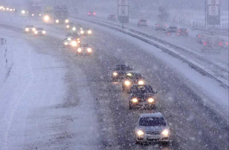 Das Bild zeugt eine stark verschneite Autobahn mit viel Verkehr.