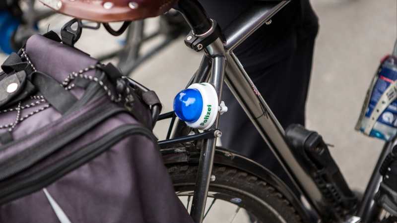 Ein Fahrrad hat ein kleines Polizeilicht unter den Sattel geschraubt.