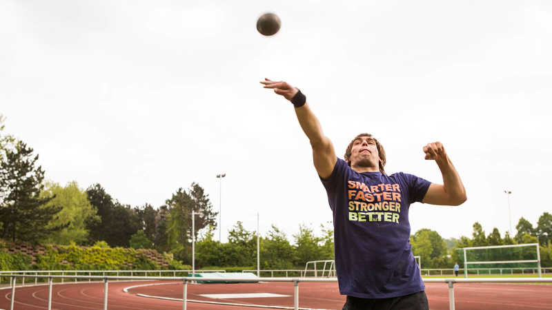 Sebastian Dietz stößt eine Kugel auf einem Sportplatz.