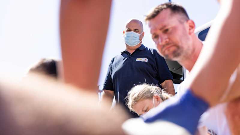 Ein Notfallsanitäter beobachtet genau, wie sich die Auszubildenden in einer Übung verhalten.