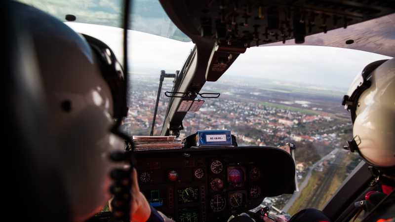 Das Bild zeigt zwei Rettungsflieger im Cockpit des Hubschraubers während einem Rettungseinsatz.