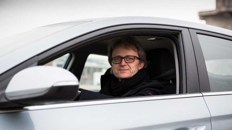 Der E-Auto-Besitzer Marcel Tippmann sitzt in seinem Auto.