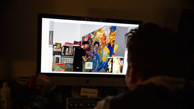 Philipp Zumhasch sieht sich ein Bild seines verstorbenen Freundes John an, der an einem Kunstwerk arbeitet.