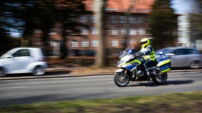 Ein Polizist fährt auf einem Polizei-Motorrad. 
