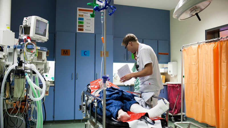 Florian Kunz unterhält sich mit der Patientin auf dem OP-Bett.