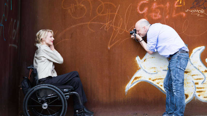 Nina Wortmann wird vor einer rostigen Wand mit Graffiti fotografiert.