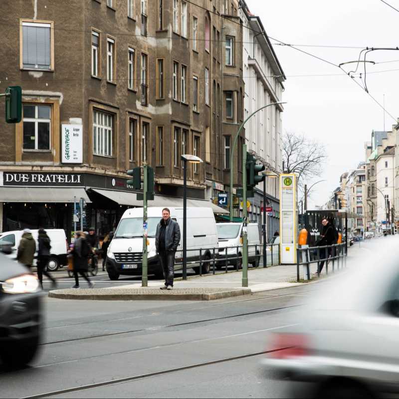 Verkehrspsychologe Haiko Ackermann steht an einer Tramstation inmitten einer vielbefahrenen Straße.