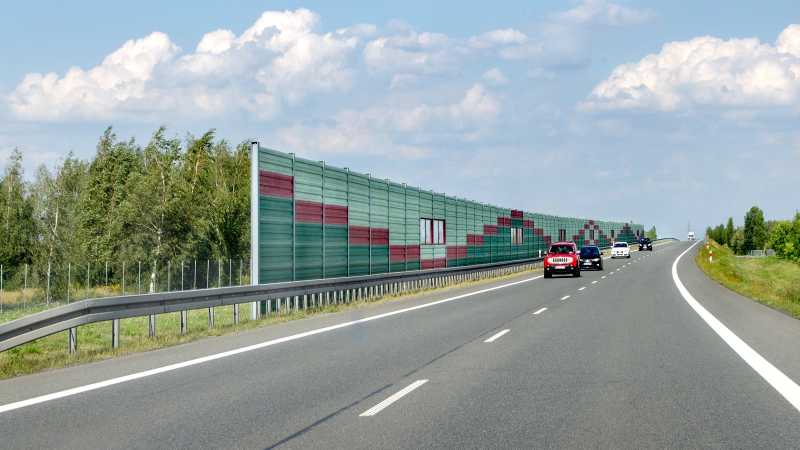 Das Bild zeigt eine zweispurige Autobahn mit einer Lärmschutzwand.