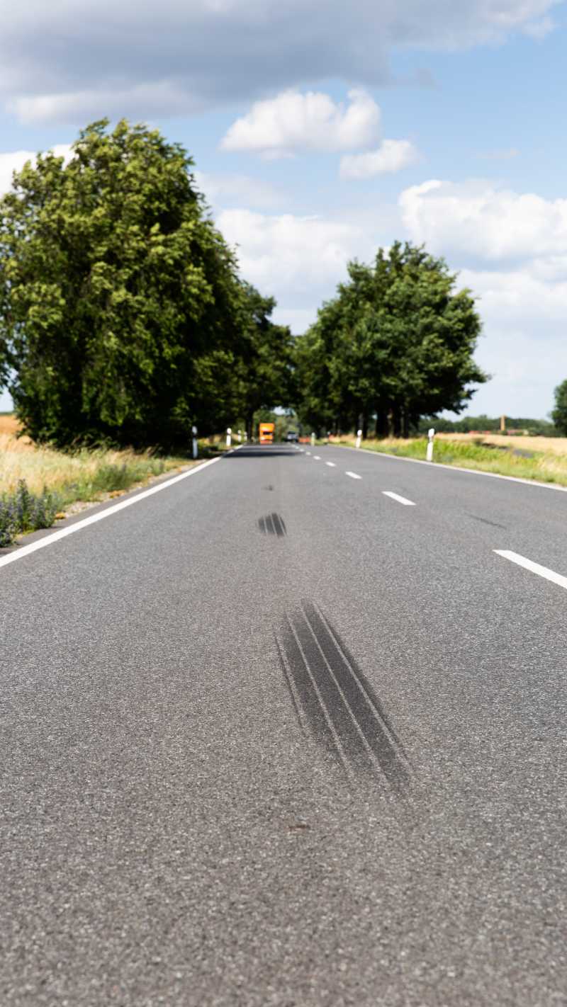 schwarze Bremsspuren auf einer Landstraße