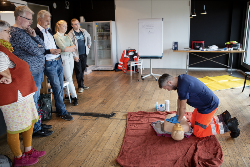 Ein Rettungssanitäter zeigt eine Herzdruckmassage an einer Puppe.