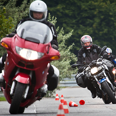 Das Bild zeigt drei Motorräder, die im Slalom einen Parkuhr durchfahren.