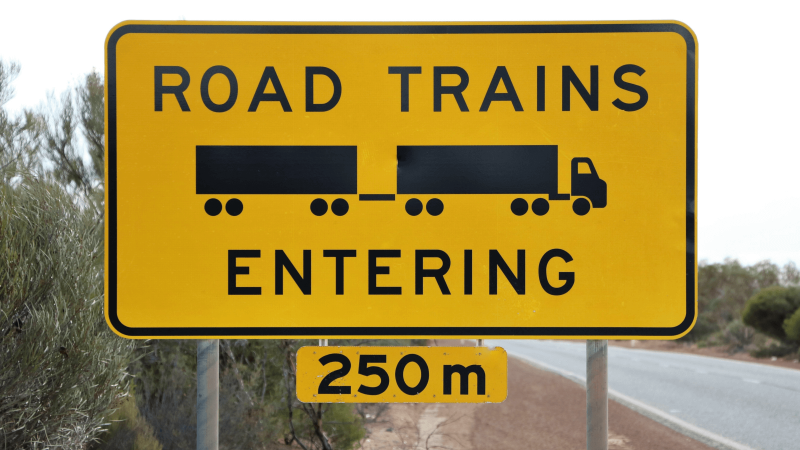 Das gelbe Verkehrsschild aus Australien warnt vor großen Trucks auf der Strecke.