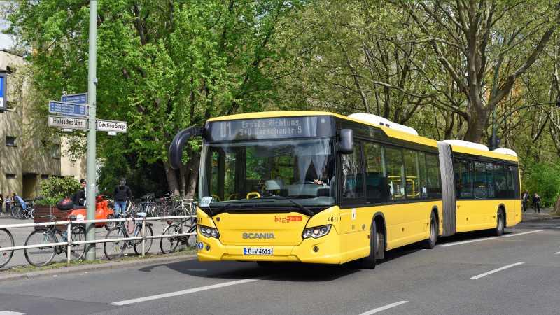 Ein gelber Bus der BVG fährt von einer Haltestelle los.