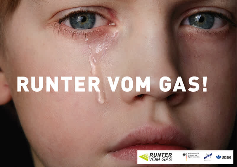 Dieses Autobahnplakat stammt aus dem Jahr 2017. Es zeigt eine Nahaufnahme eines weinenden Kindes mit einer Träne auf der Wange. Der Text „RUNTER VOM GAS!“ steht groß über dem Gesicht. Unten rechts sind die Logos der Kampagne „Runter vom Gas“ und ihrer Partner zu sehen. Das Plakat mahnt auf emotionale Weise vor den Folgen von überhöhter Geschwindigkeit.