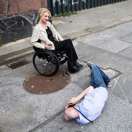 Der Fotograf Konstantin Eulenburg liegt auf dem Boden und fotografiert Nina Wortmann von unten.