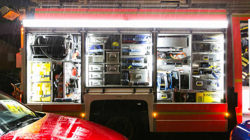 Das Bild zeigt das Equipment im Innenraum eines Feuerwehrfahrzeugs. Es ist Nacht, der Innenraum ist beleuchtet und das Team befindet sich in einem Einsatz.
