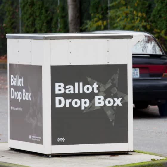Das Bild zeigt eine Wahlschein-Box, bei der im Vorbeifahren gewählt werden kann. 