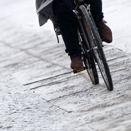 Ein Fahrrad fährt auf einem verschneiten Fahrradweg.