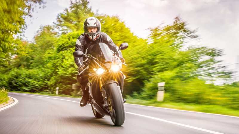 Das Bild zeigt einen auf die Kamera zufahrenden Motorradfahrer in einer Kurve.