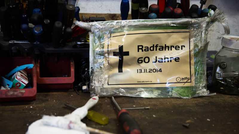 Ein kleines Schild, das an einem alten Geisterrad hing, auf dem steht: Radfahrer, 60 Jahre.