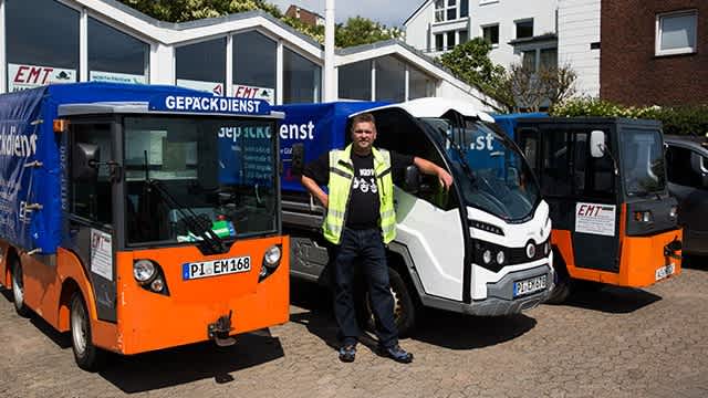 Heiko Ederleh steht vor den elektronischen Fahrzeugen seines Gepäckdienstes.