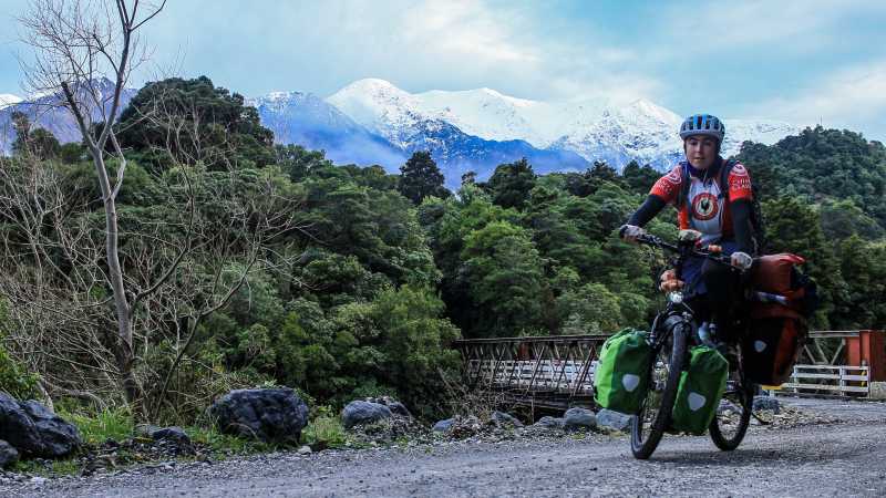 Luisa Rische sitzt auf ihrem Fahrrad vor den Ausläufern der neuseeländischen Alpen.