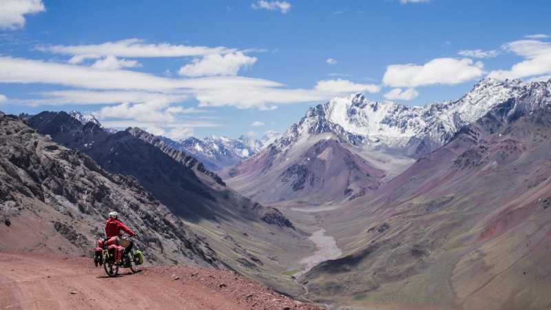 Luisa Rische steht mit ihrem Fahrrad vor den Bergen der Anden in Argentinien.